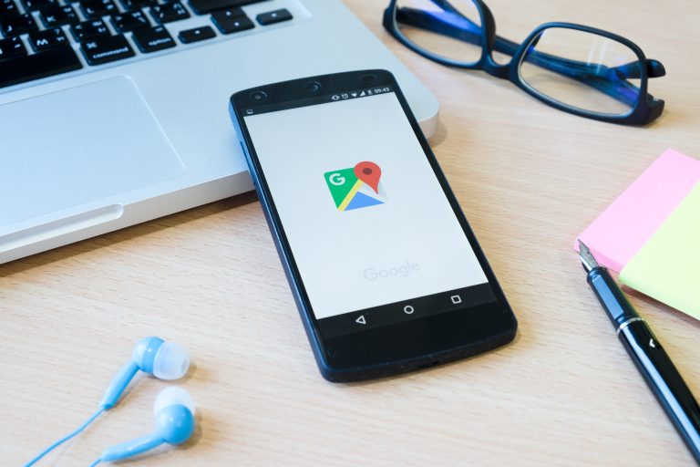 celular sobre um desktop apresentando o ícone do google maps